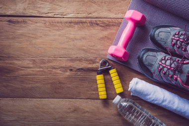Ahşap arka planda egzersiz ekipmanları ile fitness kavramı.