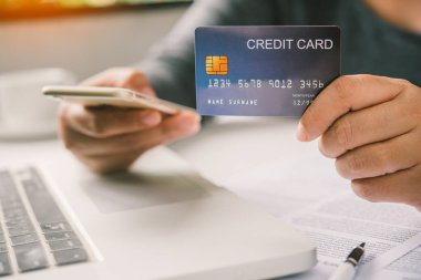 Online ödeme, kredi kartı tutan ve online alışveriş için akıllı telefon kullanarak eller