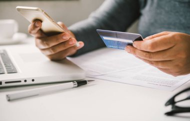 Online ödeme, kredi kartı tutan ve online alışveriş için akıllı telefon kullanarak eller