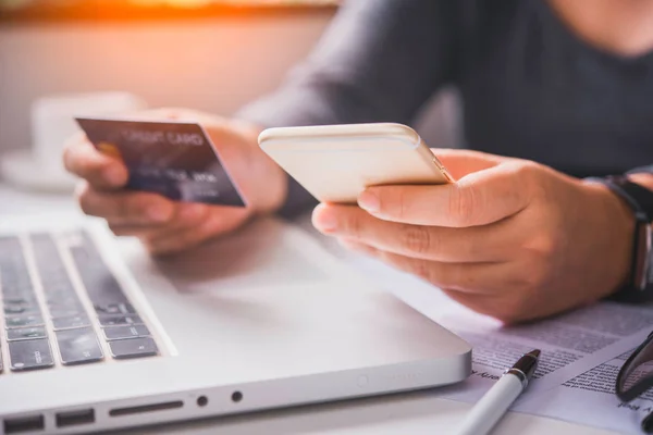 Online ödeme, kredi kartı tutan ve online alışveriş için akıllı telefon kullanarak eller