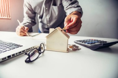  Ahşap ev, gayrimenkul yatırım ve house mortgage mali kavramı ile para madeni para koyarak el iş