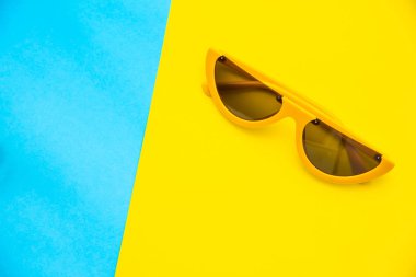 Renkli arka plan üzerinde güneş gözlüğü için üstten görünüm.