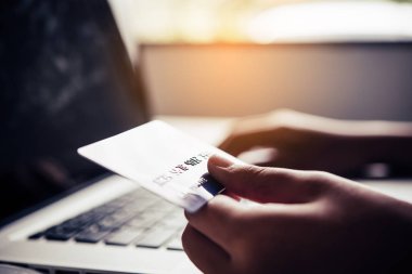 Ellerinde bir kredi kartı tutuyorlar ve online alışveriş yapmak ve finansal işlemler yapmak için mobil cihazlarını kullanan bir ürün hakkında bilgi topluyorlar..