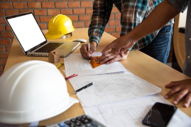 Mühendisler sunmak ve kavramları tartışmak ve iş için doğrudan inşaat planına işaret ediyor 