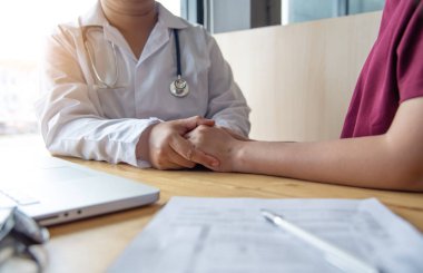 Doktorun eli kadın hastasına güvence veriyor.