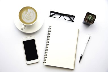 Kopya alanı, çalışma masası dizüstü bilgisayar, cep telefonu, defter kalem ve beyaz arka plan üzerinde kahve ile Üstten Görünüm