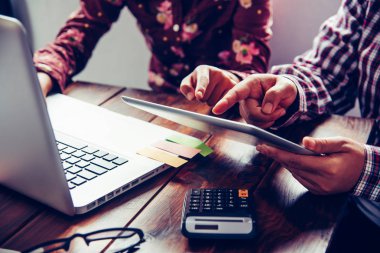 İş ekibi dizüstü bilgisayar ve açık alan Office hesap makinesi çalışıyor. Toplantı rapor devam ediyor