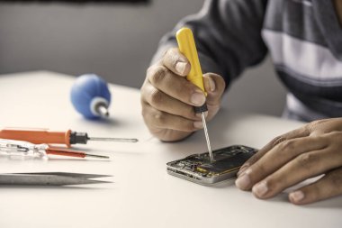 Tamirci tamirci tornavida ile Smartphone sökülmesi sökülmesi.