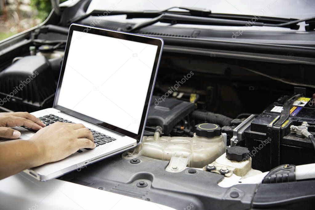 Professional mechanic checking car engine search for data with laptop and connect data system on car
