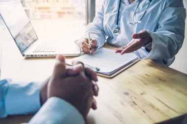 Doktor, sonuçların ve tedavi yönergelerinin fiziksel muayenesinden sonra hastayla tartışıyor..