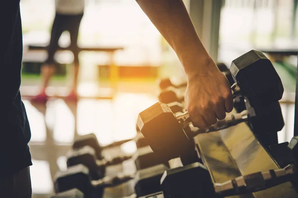 Young man exercise in a professional gym with a selection of exercise equipment.