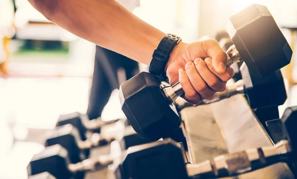 Young man exercise in a professional gym with a selection of exercise equipment.