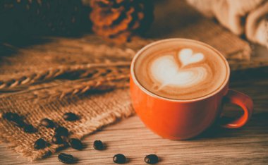 Kırmızı kahve cam ahşap zemin üzerinde duruyor. kavram natürmort