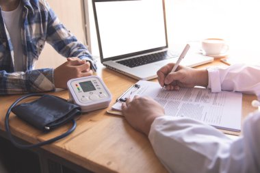 Doktor, sonuçların ve tedavi yönergelerinin fiziksel muayenesinden sonra hastayla tartışıyor..