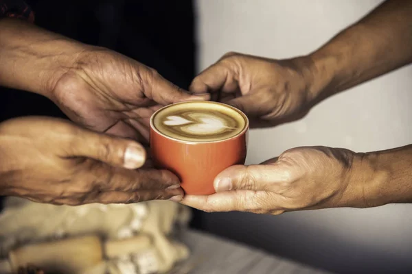 Barista\'s hands are delivering coffee to customers.