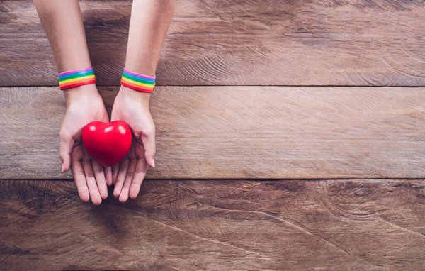 Mani Con Braccialetto Colore Arcobaleno Posizionato Pavimento Legno — Foto Stock