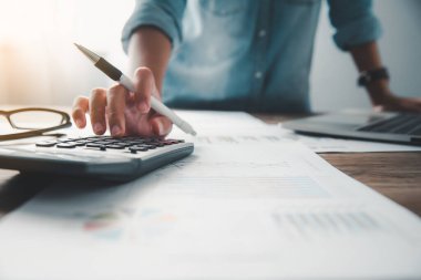  İş adamı, çalışmak için hesap makinesini kullanarak ofiste masa başında oturuyor. İş Konsepti Analizi ve Planlaması