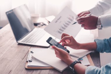 Analiz, kavramsal analiz ve iş planlaması için grafik şarj ederek ofiste birlikte çalışan ve iletişim kuran bir grup iş adamı