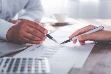 Analiz, kavramsal analiz ve iş planlaması için grafik şarj ederek ofiste birlikte çalışan ve iletişim kuran bir grup iş adamı