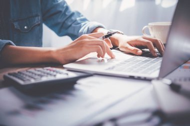 İş adamı ofis masasındaki dizüstü bilgisayarda oturuyor. İş analizi ve planlama kavramını