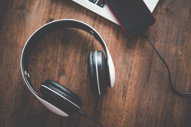 Kulaklıklar laptopla birlikte masanın üstünde. Rahatlamak için müzik fikirleri