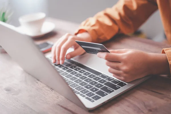 Kadınların elinde bir kredi kartı var ve çevrimiçi alışveriş için online ödeme yapıyorlar.