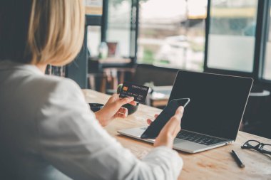 Kadınların elinde bir kredi kartı var ve çevrimiçi alışveriş için online ödeme yapıyorlar.