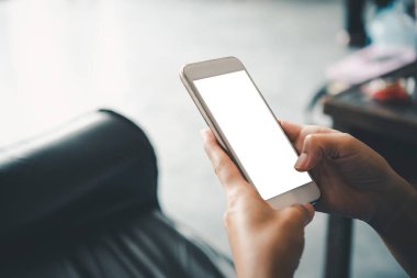 Asyalı iş kadını eli beyaz boş ekranlı akıllı telefonu kullanıyor ve ona dokunuyor..