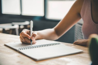 Kadın elinin kağıda yazdığı yakın plan.