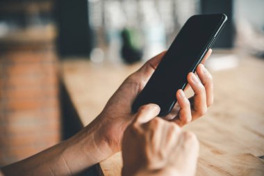 Asyalı iş kadını eli beyaz boş ekranlı akıllı telefonu kullanıyor ve ona dokunuyor..