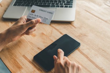 Kadınların elinde bir kredi kartı var ve çevrimiçi alışveriş için online ödeme yapıyorlar.