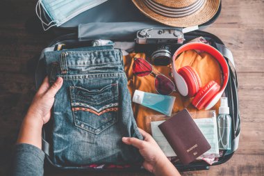 Turistler seyahat için bavul hazırlıyorlar. Konsept turizm planlaması ve yeni normal seyahat