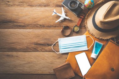 Yolculuk sırasında COVID-19 'u koruyorum. Seyahat aksesuarları kostümleri. Pasaportlar, bavullar, yolculuk için hazırlanmış seyahat haritaları.
