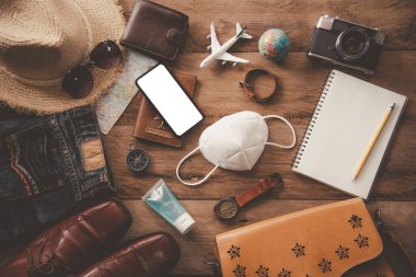 Yolculuk sırasında COVID-19 'u koruyorum. Seyahat aksesuarları kostümleri. Pasaportlar, bavullar, yolculuk için hazırlanmış seyahat haritaları.