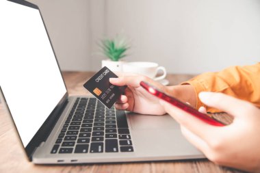 Kadınların elinde bir kredi kartı var ve çevrimiçi alışveriş için online ödeme yapıyorlar.
