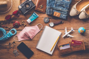 Yolculuk sırasında COVID-19 'u koruyorum. Seyahat aksesuarları kostümleri. Pasaportlar, bavullar, yolculuk için hazırlanmış seyahat haritaları.