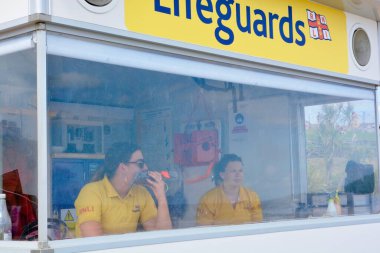 Barry, Glam / Galler Vadisi - 27 Haziran 2020: İnsanlar küçük gruplar halinde, sosyal mesafeli bir plaj gününün tadını çıkarmayı öğrenirler. Birbirlerinden uzak dururlar. Polis devriyesi ama herkes yeni özgürlüğünden çok memnun.