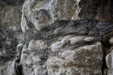 Sahildeki çakıl taşlarının, taşların ve kayaların doğal arkaplan ve dokuları. Gri, karamsar ve fırtınalı bir gün. Farklı boyutlarda, farklı şekillerde. Her biri aşınmış, bu yüzden hiçbir kaya aynı değil..