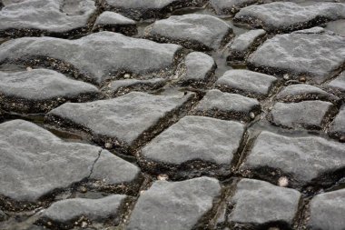 Sahildeki çakıl taşlarının, taşların ve kayaların doğal arkaplan ve dokuları. Gri, karamsar ve fırtınalı bir gün. Farklı boyutlarda, farklı şekillerde. Her biri aşınmış, yani hiçbir kaya aynı değil, hiçbir fay hattı aynı değil..