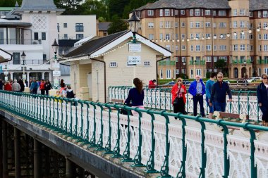 Penarth, Cardiff / Wales UK - 5 Temmuz 2020: Penarth Viktorya İskelesi 'nde haftalarca kilitli kaldıktan sonra nihayet açıldı. Aileler, arkadaşlar fırtınalı gökyüzünün altında fırtınalı rüzgarda sahil boyunca yürür.