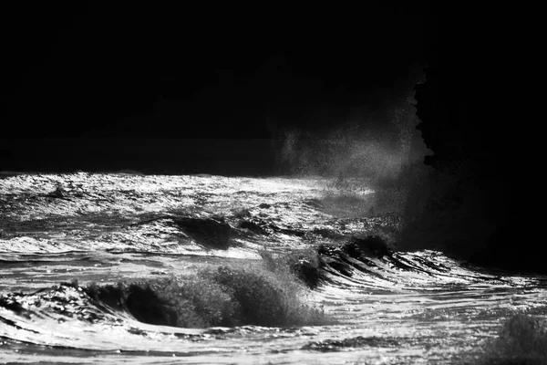 大风和涨潮的汹涌大海造成巨浪 在岩石海滩上冲撞 落日在水面上闪烁着光芒 浪花在水面上形成了薄雾 — 图库照片