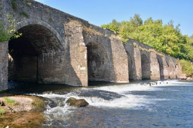 Monmouth, Wales 'daki ABERGAVENY' deki Nehir Üssü. Nehir boyunca uzanan ve şehir merkezindeki çayırların yanından geçen antik köprü. Nehir ve kırsal alan bozulmamış doğal güzelliklerin manzarasını sunar.. 