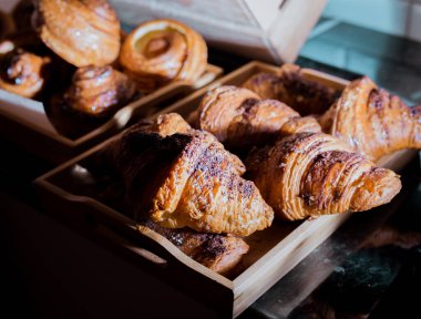 Tatlı çikolatalı kruvasanlar seçici odaklanma ve arka planda çörekler.