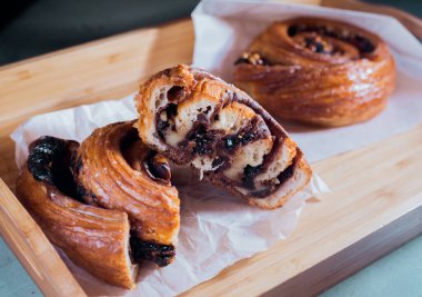 Kafedeki ahşap masada tarçınlı ve çikolatalı çörek..