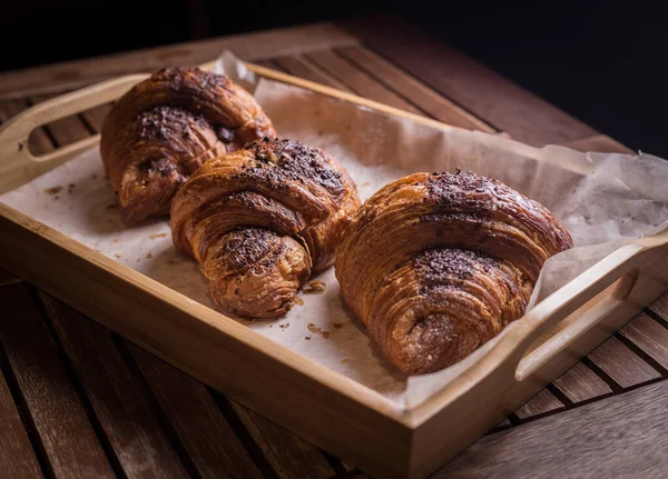 Tatlı çikolatalı kruvasanlar. Ahşap arka plana özen gösteriyorlar..