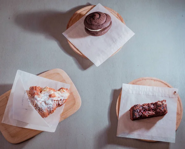 Turta, bademli kruvasan, kafedeki ahşap masada browni..