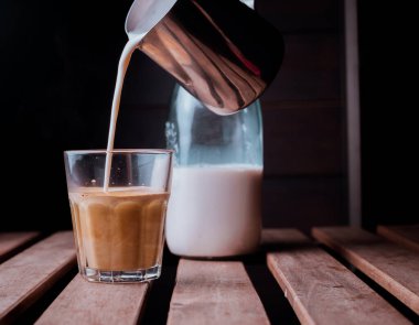 Barista cappuccino yapıyor, barmen kahve dolduruyor. Siyah arkaplan