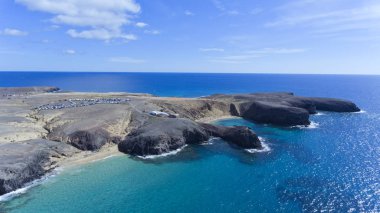 Lanzarote Sahil tarafından kumlu plajları ile havadan görünümü açık deniz suları, koyları, volkanik arazi, bir güneşli yaz gününde, Papagayo, Kanarya Adaları, İspanya .