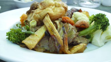 Geleneksel İngilizce Pazar öğle yemeği Yorkshire pudingi gıda, et, kızarmış patates, havuç, brokoli, karnabahar, fasulye, bir beyaz tabakta dilimleri