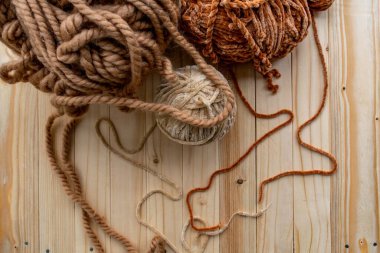 İplik bej, kahverengi ve açık kahverengidir. Hafif odunların arka planı. Örgü, örgü, örgü.